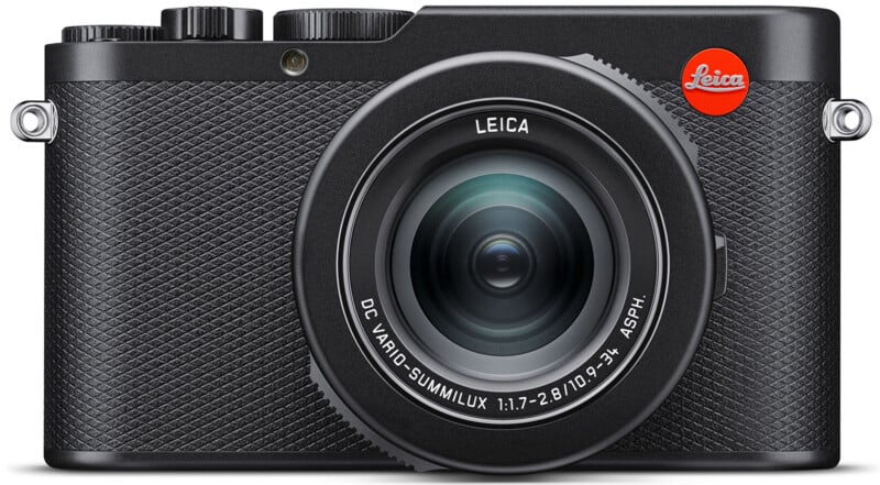 Front view of a black Leica digital camera with a textured grip.  The lens reads "DC VARIO-SUMMILUX 1:1.7-2.8 / 10.9-34 ASPH." Control buttons are located at the top left and a red Leica logo is located at the top right.