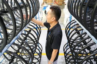 A worker in a wheel factory looks at rims