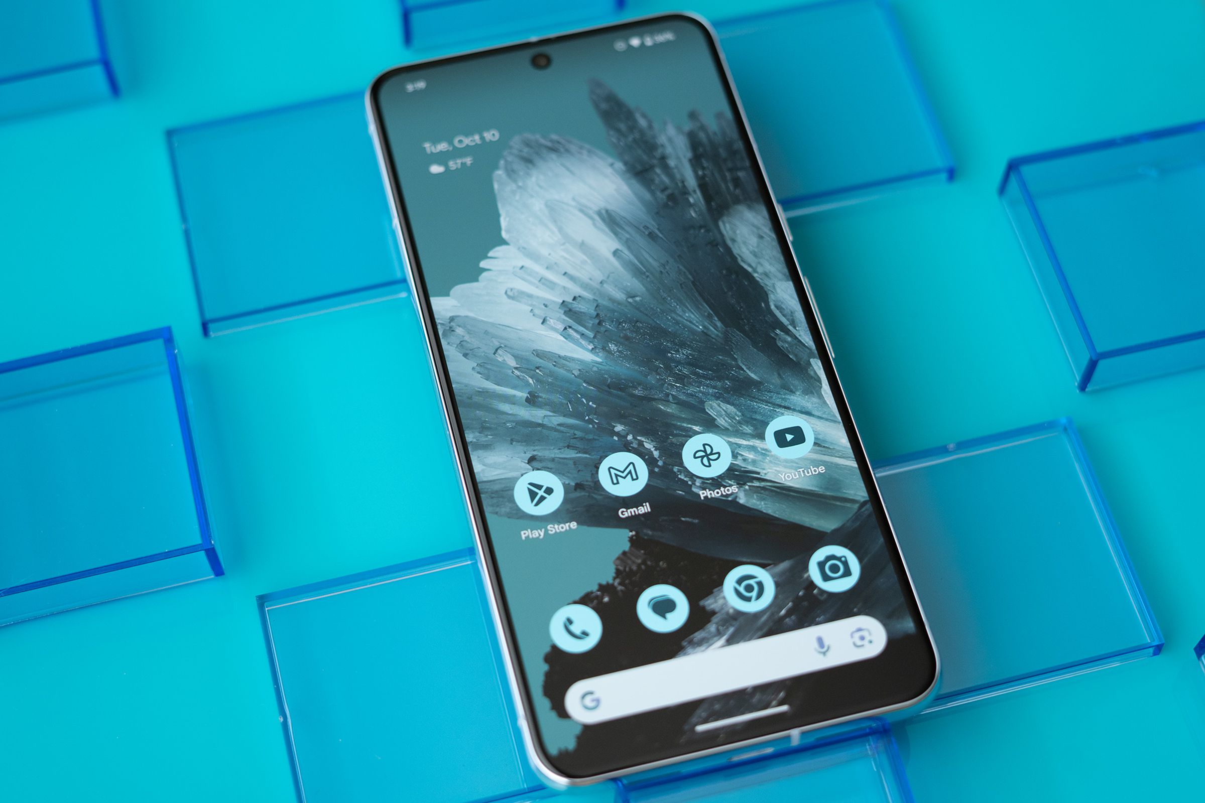 Google Pixel 8 Pro face up, showing the home screen and blue mineral background