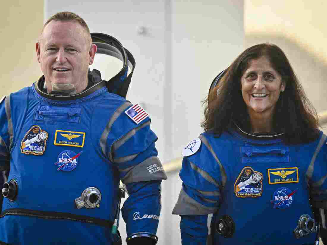 NASA astronauts Butch Wilmore (L) and Suni Williams, dressed in Boeing space suits, as they leave the operations and checkout building for the launch pad at the Kennedy Space Center in Florida on Wednesday.  It is the third trip to space for both of them.