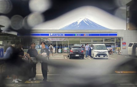 Mount Fuji can be seen through a hole on a black screen installed opposite a supermarket in the city of Fujikawaguchiko.