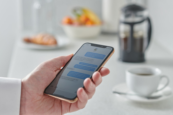 Man using smartphone in the kitchen