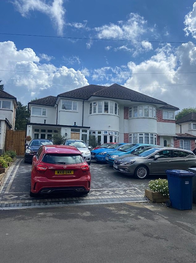 The paved front garden which is furnished as a second-hand car parking lot