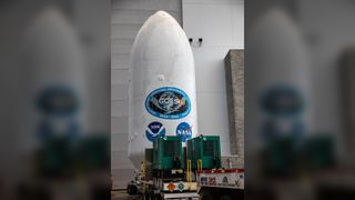 a large white cylinder with a NASA logo and an emblem reading 