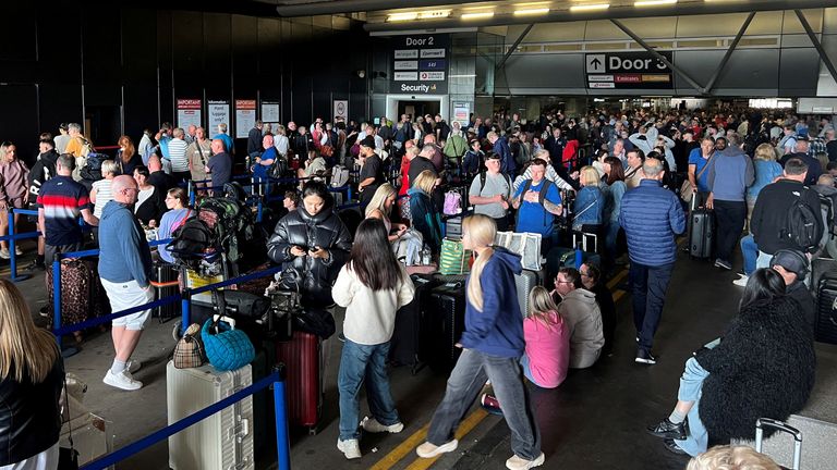 Passengers queue outside Terminal 1. Photo: Reuters