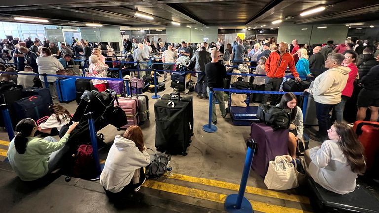 Passengers queue outside Terminal 1. Photo: Reuters