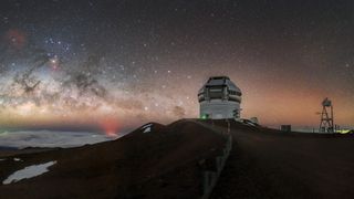 a telescope on a mountain top under a very starry sky