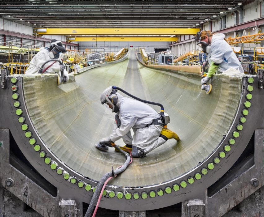 Sanding injected fiberglass into a wind turbine blade housing.