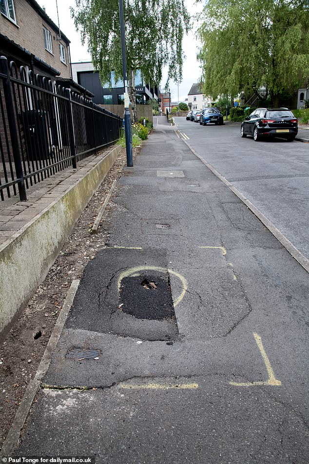 A hole in the sidewalk opposite the house, which residents believe the municipality should make a priority