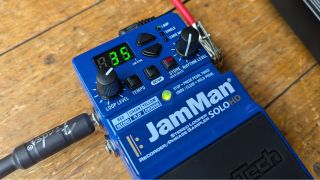 The front panel of a DigiTech JamMan looper pedal connected to a pedalboard