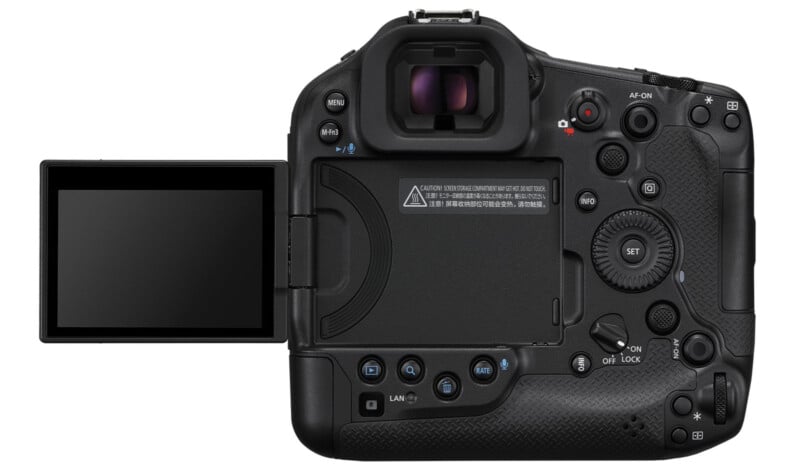 Rear view of a black digital camera with a flip-out LCD screen that is extended to the left. The camera has numerous buttons, dials and a viewfinder on the top. Notable labels include AF-ON, SET, MENU, INFO and a joystick control.