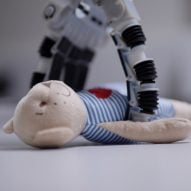 A robotic arm picking up a teddy bear