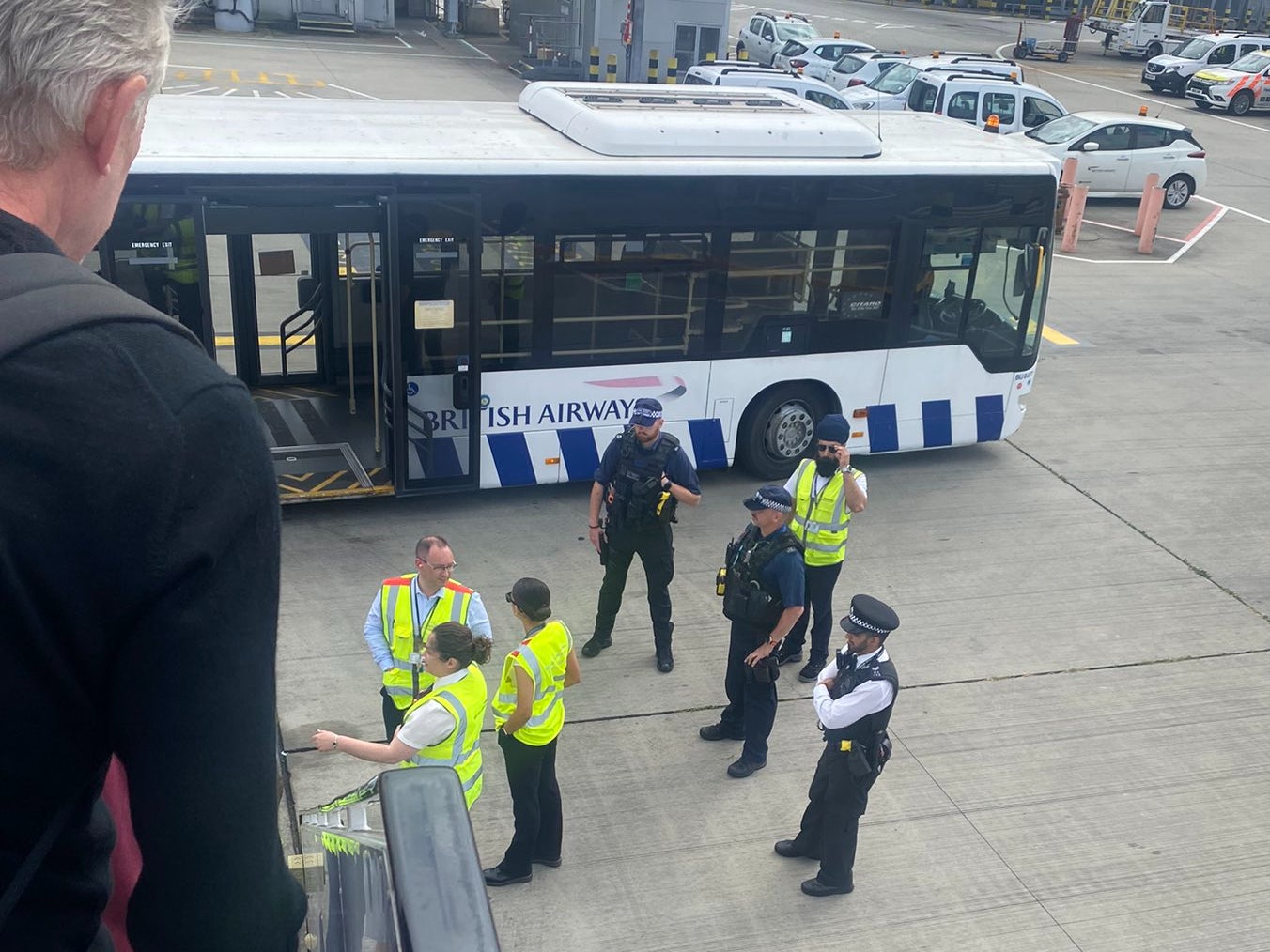 Wrong airport: British Airways staff and airport police at the bottom of the stairs of a BA Airbus A321 diverted from Gatwick to Heathrow