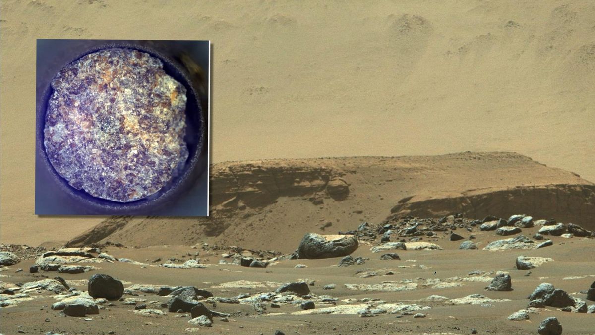 a close up of multi-colored rock against a background showing a reddish-orange dusty landscape littered with rocks