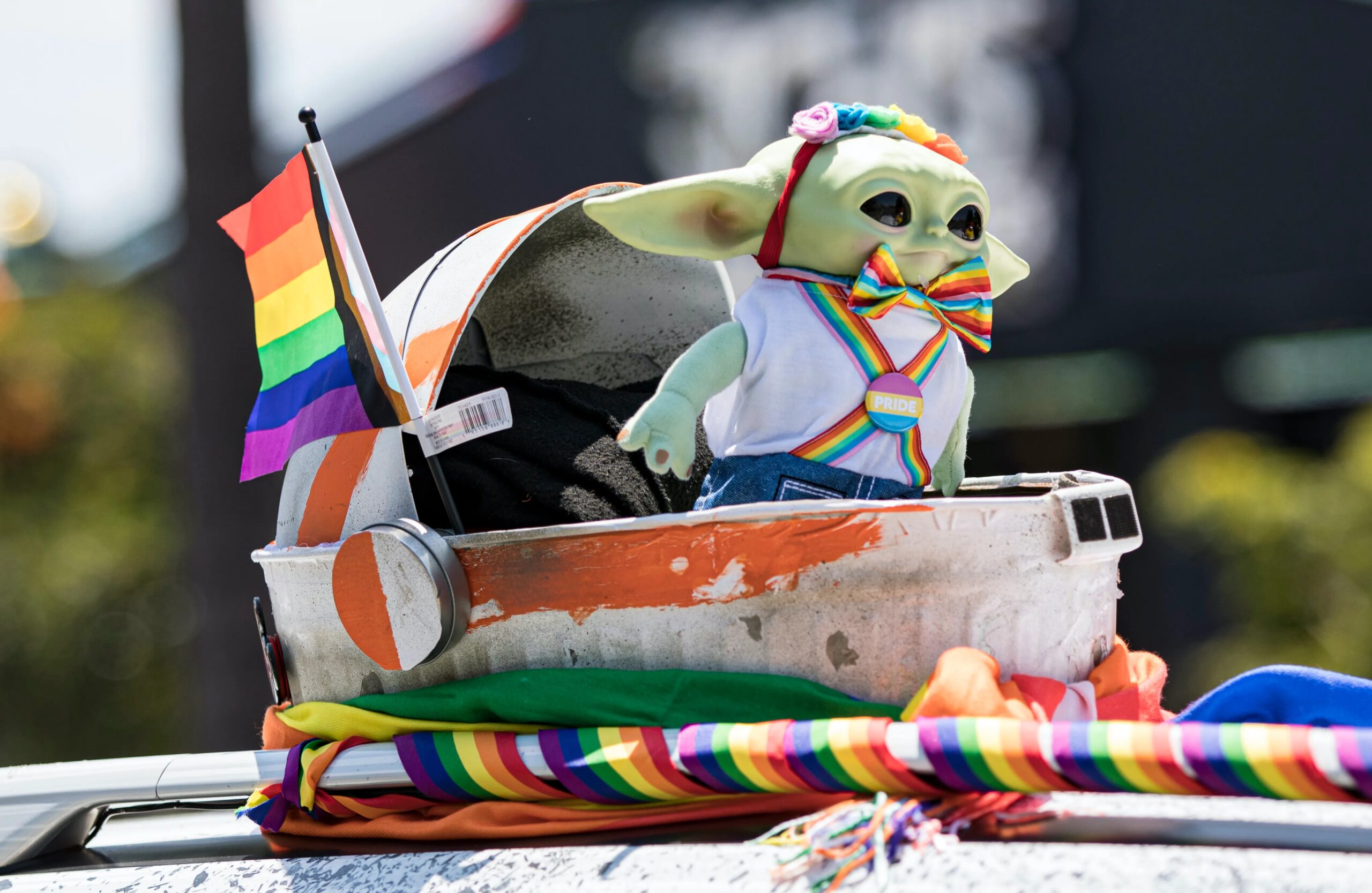 Photo taken at San Diago Pride showing Grogu from The Mandalorian in Pride themed rainbow outfit