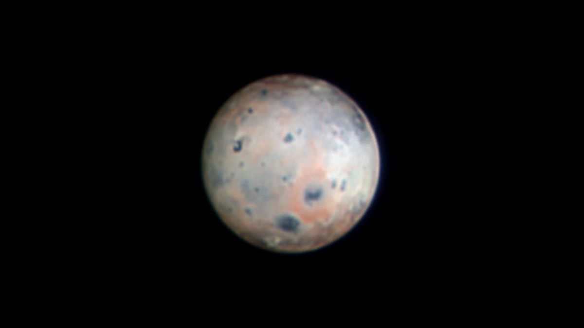 An orb against a black background. The orb has some blue spots and red areas.