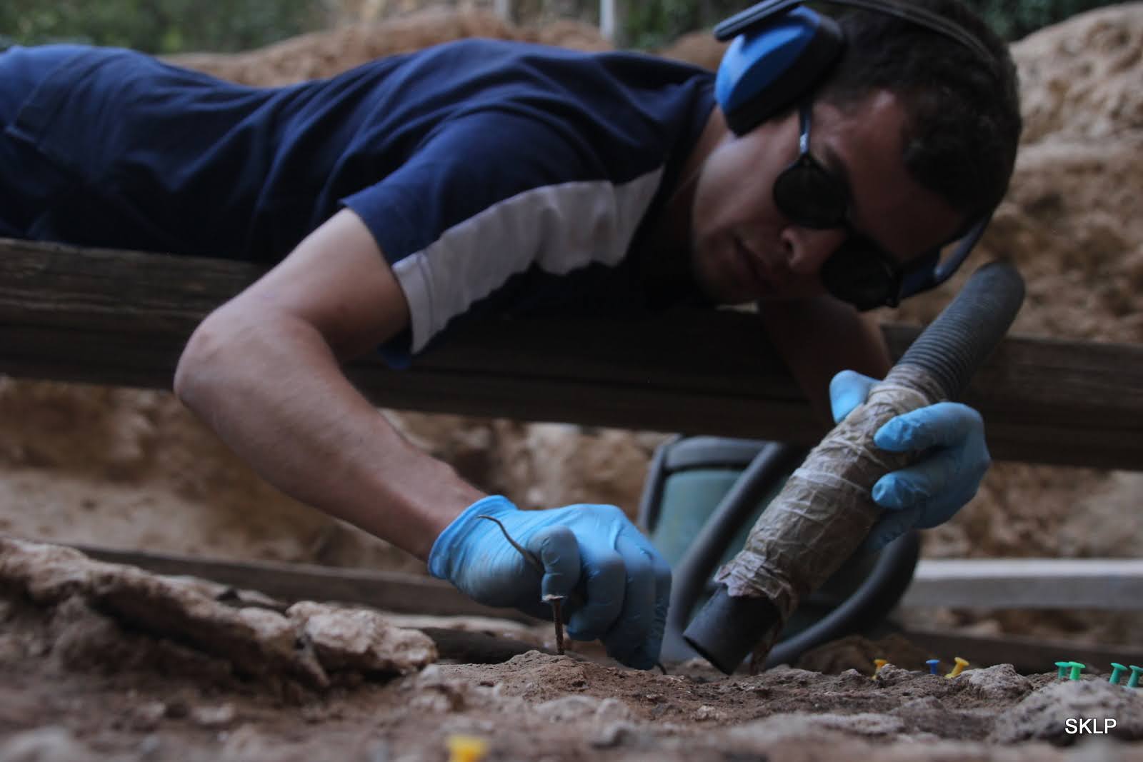 A researcher examining a Neanderthal hearth