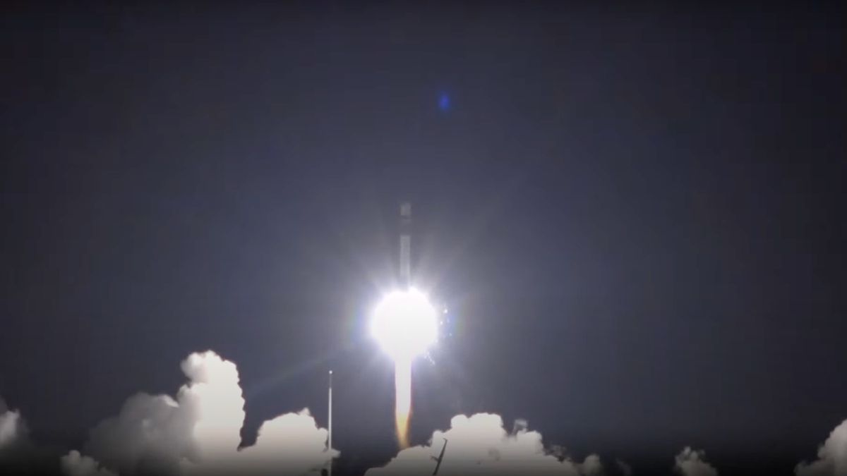 a black and white rocket launches into a night sky