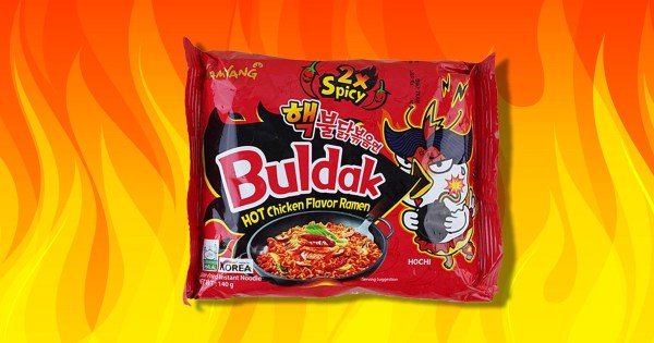 Buldak Spicy Noodles against a fiery background.